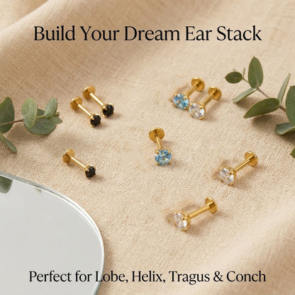 Curated minimal ear stack styling featuring a gold titanium 4-prong zircon flat back stud in the helix alongside delicate gold hoops.