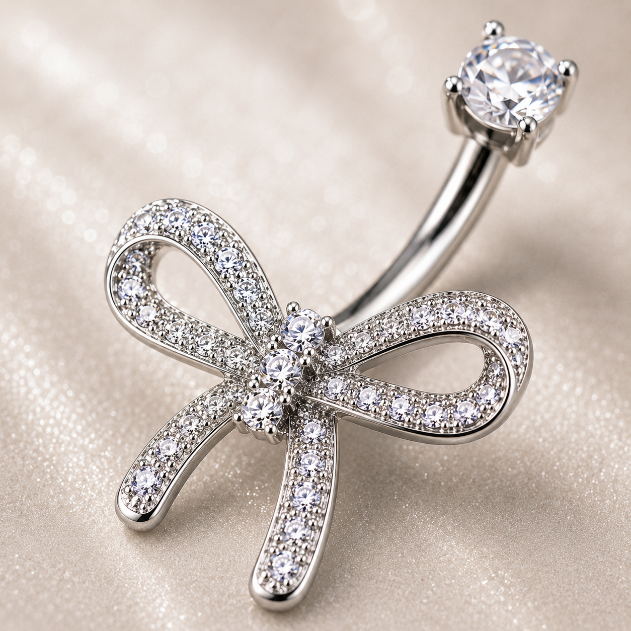 Macro shot of Dazzling Titanium Bow Belly Button Ring showing 3 vertically-aligned CZ stones, left tail shorter than right, polished titanium shine