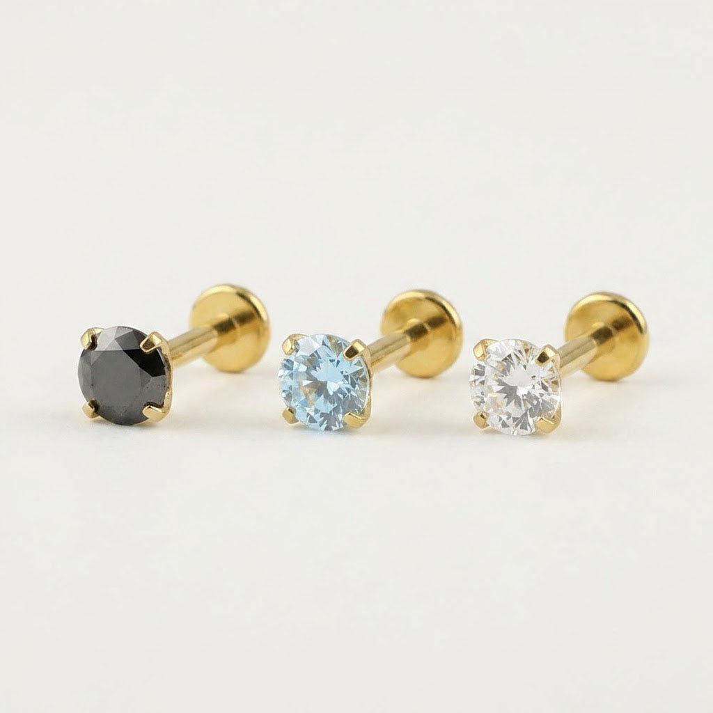 Premium mirror-polished gold titanium flat back stud earring featuring a secure 4-prong clear zircon setting for helix and tragus piercings.