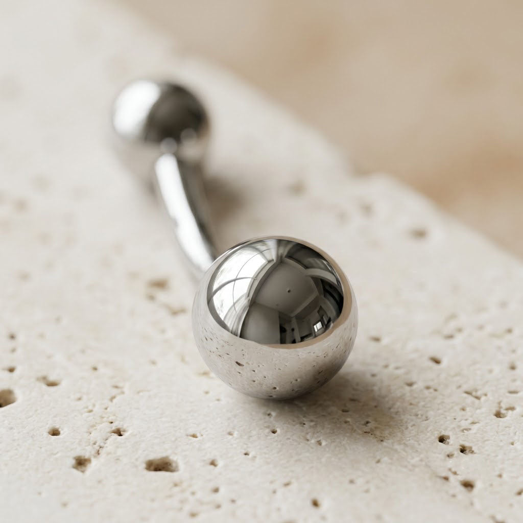 Macro photography showing the ultra-high mirror-polished surface reflections on the solid titanium 8mm bottom ball. Hypoallergenic jewelry.