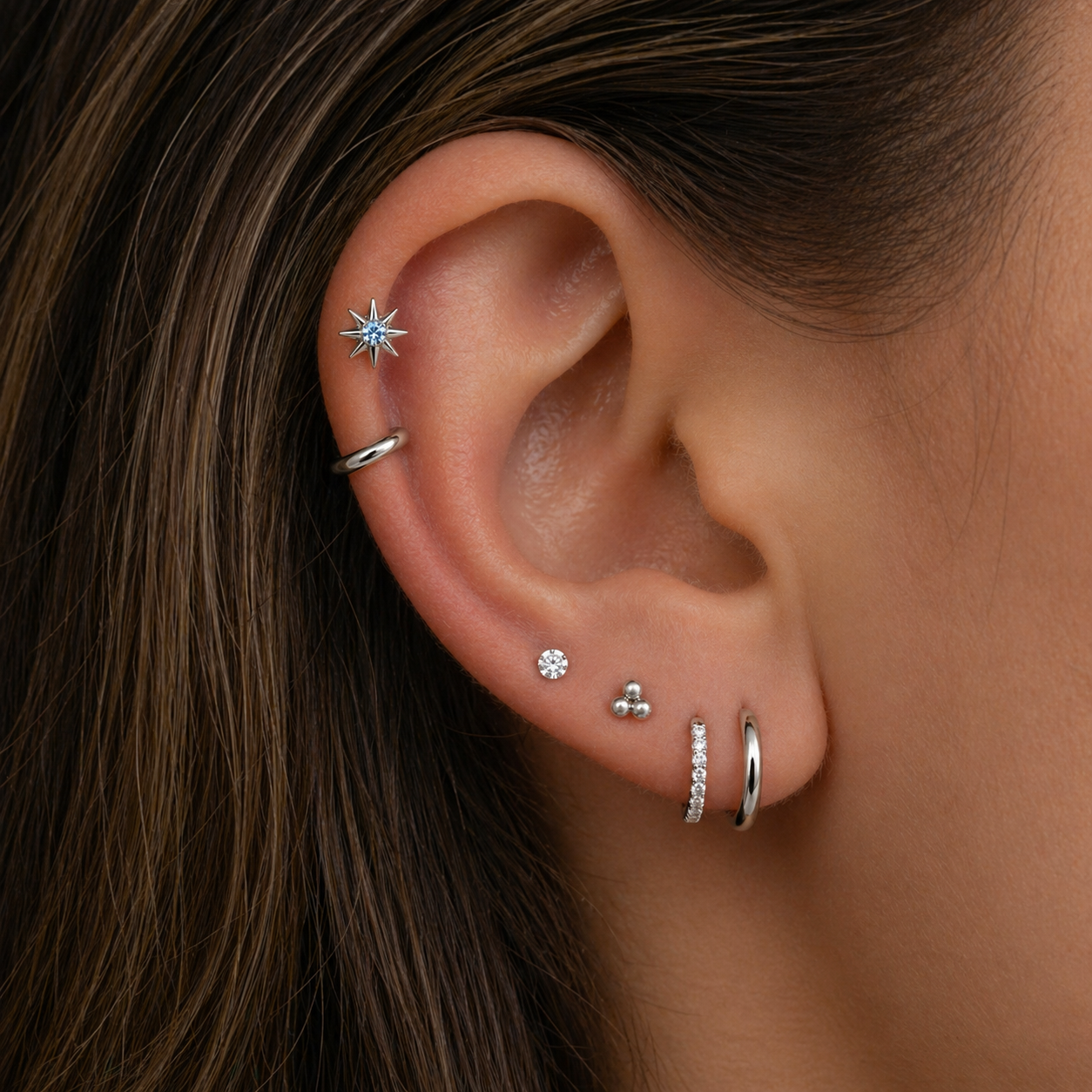Multiple ear piercings styled with titanium stud earrings