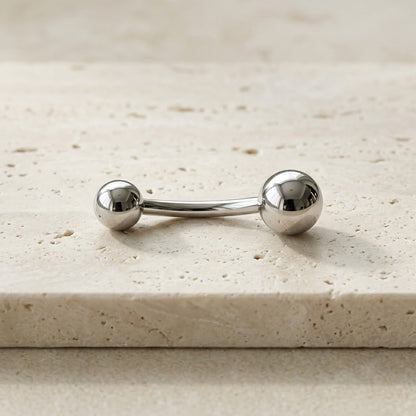 Premium high-polished mirror finish implant-grade titanium curved navel barbell, 14G, 3/8 inch.