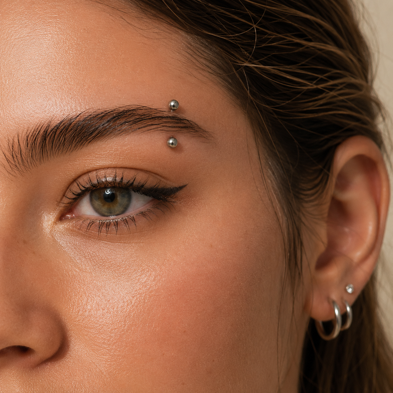 Young woman wearing a titanium ball straight barbell eyebrow piercing