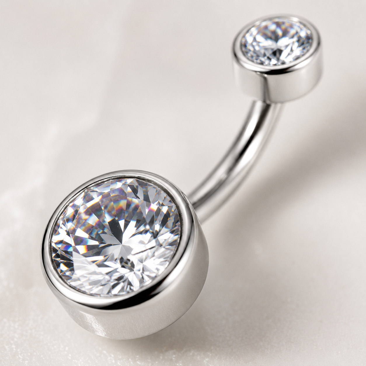 Close-up macro view of titanium belly button ring featuring brilliant cut CZ stones and mirror polished finish