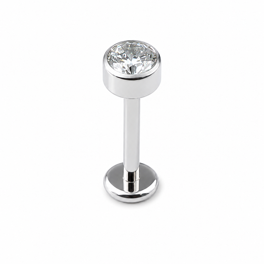 Implant grade titanium flat back labret stud with bezel set cubic zirconia and internally threaded design on white background