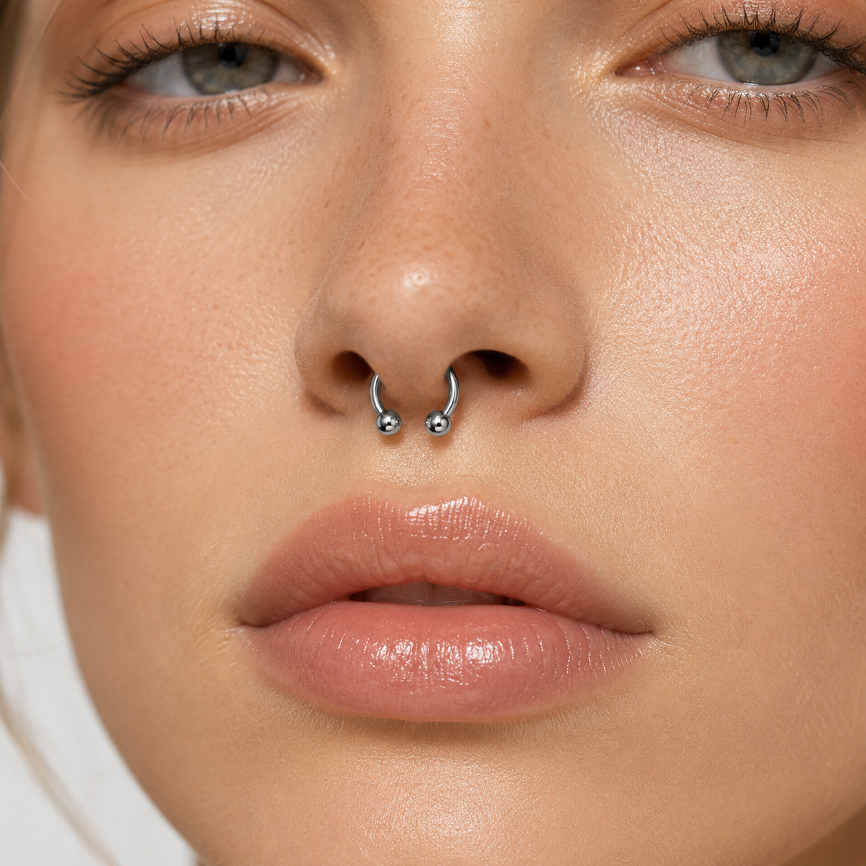 Young woman wearing a titanium horseshoe nose ring with polished double ball ends